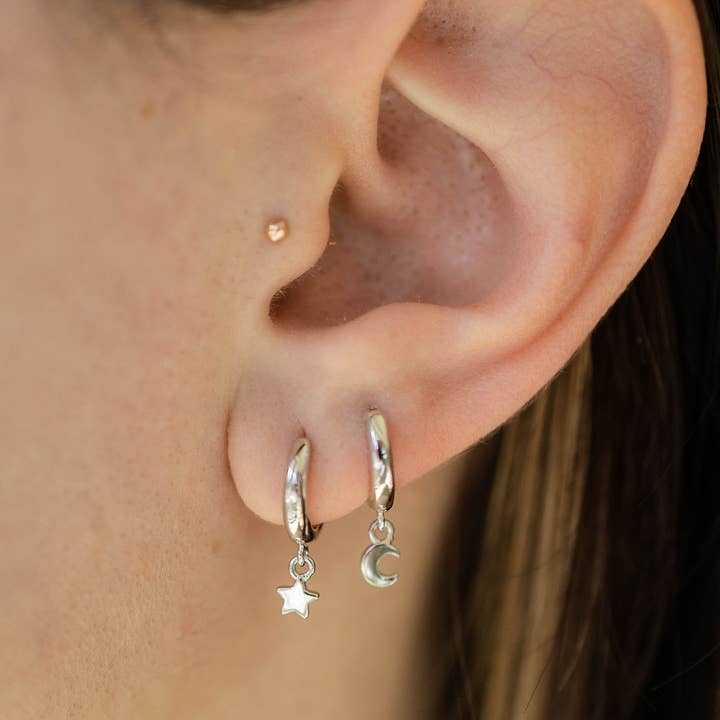 The Land of Salt Star and Moon Huggie Hoops in Silver